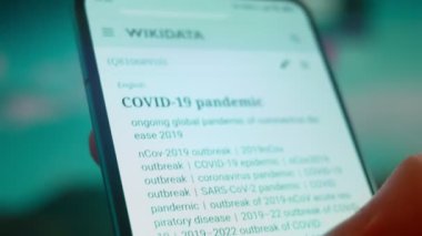 Smartphone in hand, looking for information about the coronavirus.