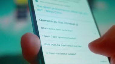 Smartphone in hand, looking for information about down syndrome.