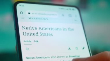 Smartphone in hand, looking for information about Native Americans.