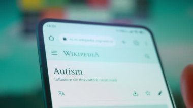 Smartphone in hand, looking for information about autism.