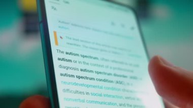 Smartphone in hand, looking for information about autism.