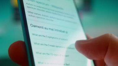 Smartphone in hand, looking for information about autism.