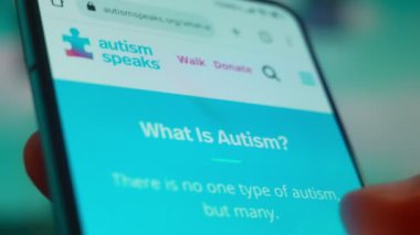 Smartphone in hand, looking for information about autism.