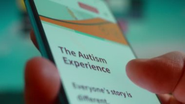 Smartphone in hand, looking for information about autism.