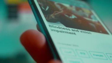 Smartphone in hand, looking for information about blindness.