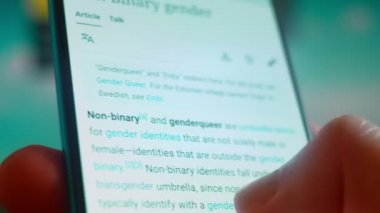 Smartphone in hand, looking for information about non binary.