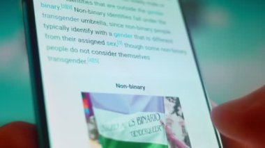 Smartphone in hand, looking for information about non binary.