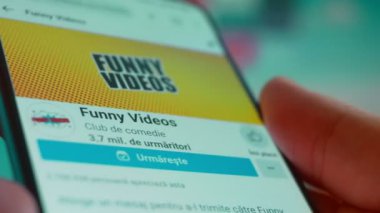 Smartphone in hand, looking for information about funny videos.