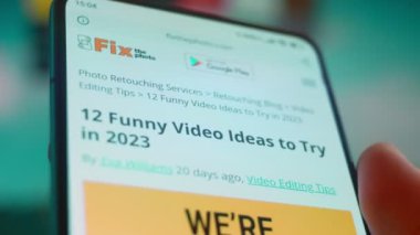 Smartphone in hand, looking for information about funny videos.