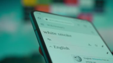 Smartphone in hand, looking for information about white smoke.