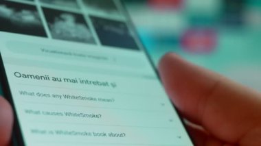 Smartphone in hand, looking for information about white smoke.