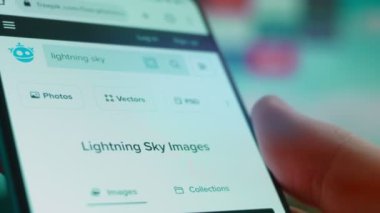 Smartphone in hand, looking for information about lightning sky.