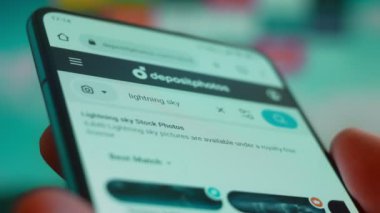 Smartphone in hand, looking for information about lightning sky.