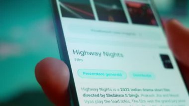 Smartphone in hand, looking for information about night clouds.