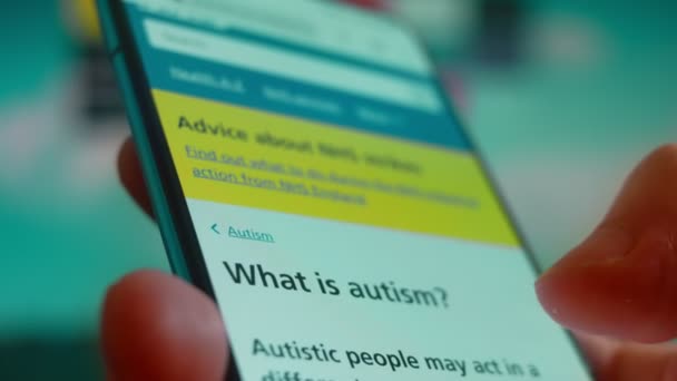 手にスマートフォン 自閉症に関する情報を探しています — ストック動画