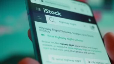 Smartphone in hand, looking for information about night clouds.
