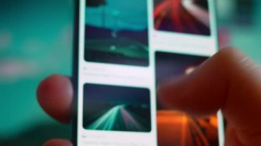 Smartphone in hand, looking for information about night clouds.