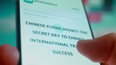 Smartphone in hand, looking for information about flying money.
