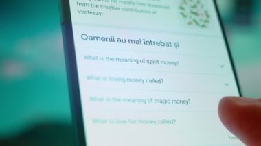 Smartphone in hand, looking for information about flying money.