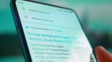 Smartphone in hand, Im looking for information on the internet about vintage background.