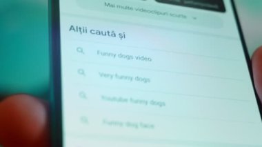Smartphone in hand, Im looking for information on the internet about funny dog.