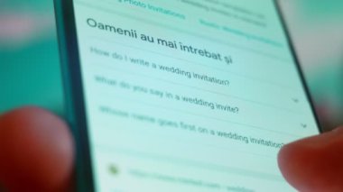 Smartphone in hand, Im looking for information on the internet about wedding invitations.