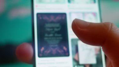 Smartphone in hand, Im looking for information on the internet about wedding invitations.