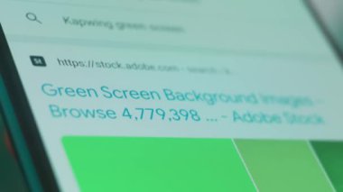 Smartphone in hand, looking for information about green screen background.