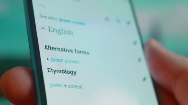 Smartphone in hand, looking for information about green screen background.