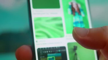 Smartphone in hand, looking for information about green screen background.