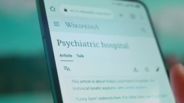 Smartphone in hand, looking for information about mental hospital.