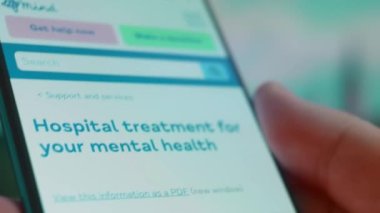 Smartphone in hand, looking for information about mental hospital.
