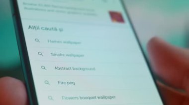 Smartphone in hand, looking for information about flame background.