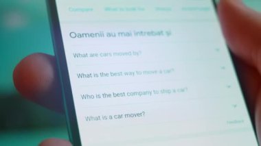 Smartphone in hand, looking for information about car moving.