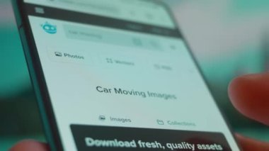 Smartphone in hand, looking for information about car moving.
