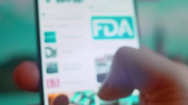 Smartphone in hand, looking for information about fda.