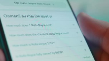 Smartphone in hand, looking for information about rolls royce.