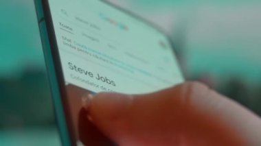 Smartphone in hand, looking for information about steve jobs.