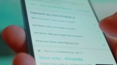 Smartphone in hand, looking for information about steve jobs.