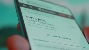 Smartphone in hand, looking for information about steve jobs.