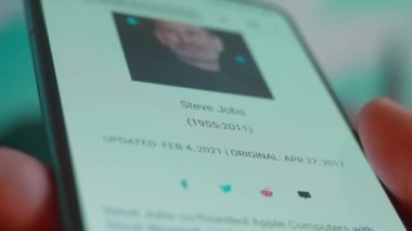 Smartphone in hand, looking for information about steve jobs.