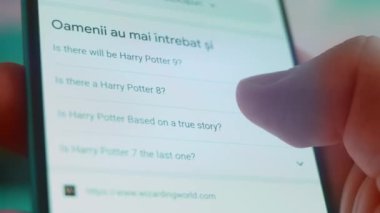 Smartphone in hand, looking for information about harry potter.