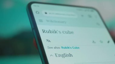 Smartphone in hand, looking for information about rubik cube.