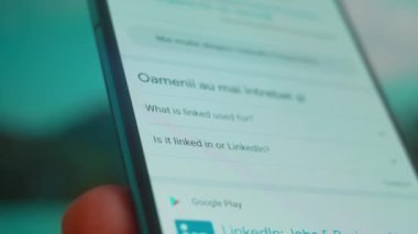 Smartphone in hand, looking for information about linked in.
