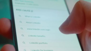 Smartphone in hand, looking for information about linked in.