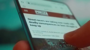 Smartphone in hand, looking for information about street racing.