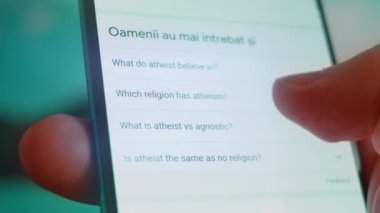 Smartphone in hand, looking for information about atheist.