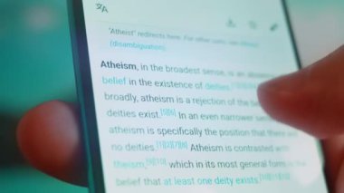 Smartphone in hand, looking for information about atheist.