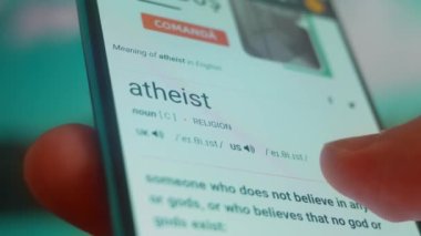 Smartphone in hand, looking for information about atheist.
