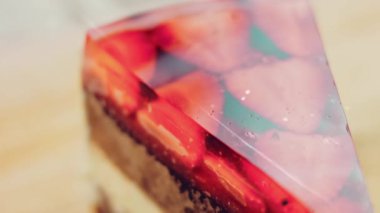 Çilek ve jöleli bir dilim pasta. Makro ve kaydırma atışı. Arka planda bir retro atmosfer var..